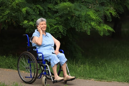 happy-elderly-disabled-woman-sitting-wheelchair-outdoors-talking-phone