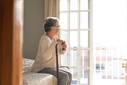 mujer-senior-pensativa-apoyandose-baston-mientras-sentado-cama-anciana-solitaria-sentada-dormitorio-casa-anciana-cabello-gris-apoyado-baston-sentado-cama-casa