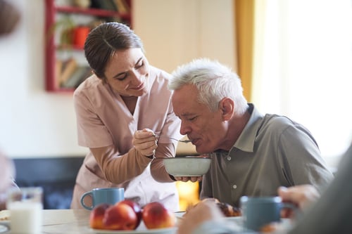 retrato-mujer-joven-sonriente-ayudando-paciente-mayor-cena-espacio-copia-hogar-ancianos