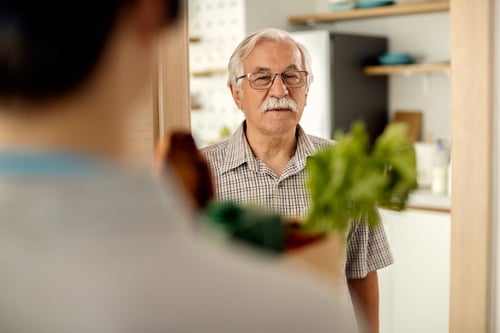 senior-man-receiving-groceries-delivery-from-courier-home