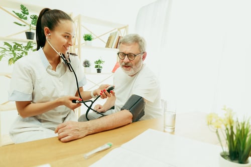 visiting-nurse-health-visitor-taking-care-senior-man