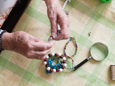 vista-de-angulo-alto-de-una-mujer-haciendo-una-pulsera-en-la-mesa