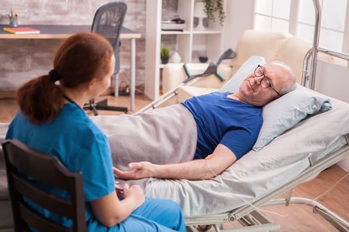 vista-posterior-doctora-hogar-ancianos-sentado-junto-al-anciano-acostado-cama